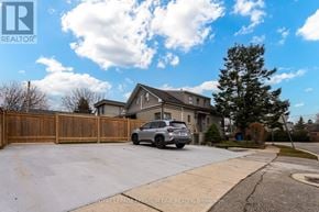 Toronto (Long Branch) fourplex for rent - A house with a garage and a car parked in front.