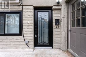 Toronto (Long Branch) fourplex for rent - A black door with a glass panel and a metal handle is on a stone building.