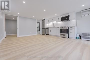Toronto (Long Branch) fourplex for rent - A spacious kitchen with white cabinets and appliances.