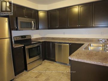 Milton (Ha Harrison) townhouse for rent - A kitchen with brown cabinets and stainless steel appliances.