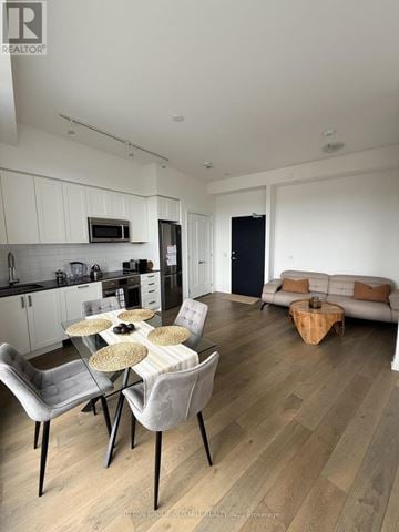 Toronto (Edenbridge-Humber Valley) condo for rent - A modern kitchen with a dining table set for four.