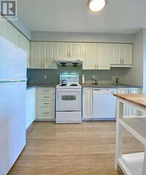 Toronto (Bendale) condo for rent - A kitchen with white appliances and cabinets.