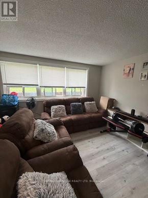 Mississauga (Streetsville) multi-family for rent - A living room with a brown couch and a television.