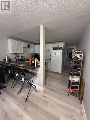 Mississauga (Streetsville) multi-family for rent - A kitchen with white cabinets and a wooden floor.