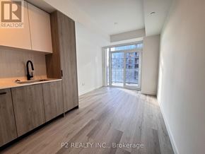 Toronto (Centennial Scarborough) condo for rent - A well-lit kitchen with wooden cabinets and a large window.