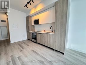Toronto (Centennial Scarborough) condo for rent - A modern kitchen with wooden cabinets and a stainless steel oven.