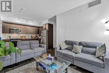 Oshawa (Windfields) condo for rent - A living room with a grey couch and a glass coffee table.