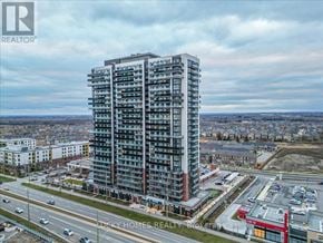 Oshawa (Windfields) condo for rent - A tall residential building is situated in a developed area with a highway and other buildings nearby.