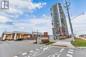 Oshawa (Windfields) condo for rent - A tall building is in the background of a street with a realtor logo on the bottom left.