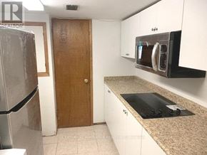 Toronto (Crescent Town) apartment for rent - A kitchen with a refrigerator, microwave, and oven.