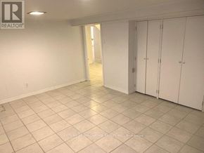 Toronto (Crescent Town) apartment for rent - A spacious room with white cabinets and tiled flooring.