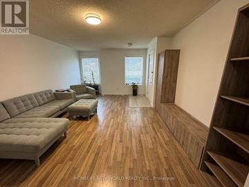 Markham (Milliken Mills East) townhouse for rent - A living room with a grey sofa and wooden flooring.