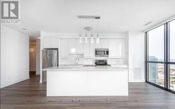 Vaughan (Concord) condo for rent - A modern kitchen with white cabinets and a large island.
