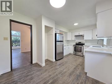 Burnaby apartment for rent - A kitchen with white cabinets and a wooden floor.