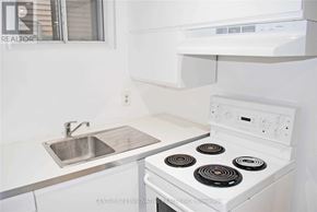 Toronto (Oakridge) apartment for rent - A white stove with a silver sink in a kitchen.