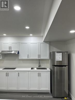 Brampton (Bram East) apartment for rent - A kitchen with white cabinets and a stainless steel refrigerator.