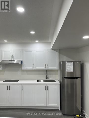 Brampton (Bram East) apartment for rent - A kitchen with white cabinets and a stainless steel refrigerator.