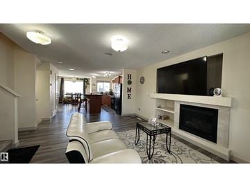 Edmonton apartment for rent - A living room with a white couch and a fireplace.