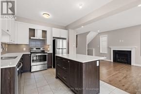 Ottawa apartment for rent - A modern kitchen with a stainless steel refrigerator, oven, and a fireplace in the living room.
