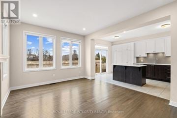 Ottawa apartment for rent - A spacious kitchen with white cabinets and a black island.