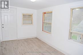 Toronto (Oakridge) apartment for rent - A room with a white door and two windows with wooden frames.