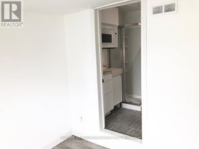 Toronto (Oakridge) apartment for rent - A white refrigerator is in a kitchen with a white wall.