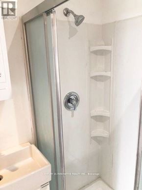 Toronto (Oakridge) apartment for rent - A shower with a glass door and a white sink.