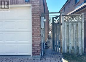 Markham (Thornlea) apartment for rent - A white garage door is closed and a wooden gate is open.