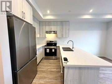 Richmond Hill townhouse for rent - A kitchen with a refrigerator on the left and a sink on the right.