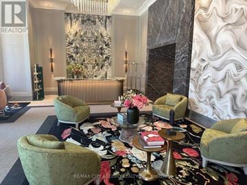 Toronto (Edenbridge-Humber Valley) condo for rent - A living room with a green chair and a gold table.