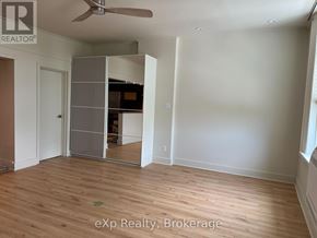 Stratford multi-family for rent - A room with a wooden floor and a ceiling fan.
