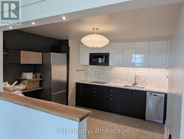 Stratford multi-family for rent - A kitchen with black cabinets and a wooden counter.