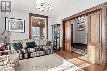 Kawartha Lakes (Verulam) apartment for rent - A living room with a striped couch and a wooden cabinet.