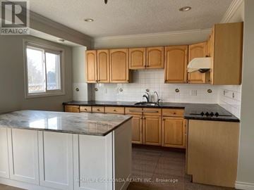 Toronto (Milliken) apartment for rent - A kitchen with wooden cabinets and a marble countertop.