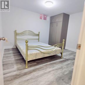 Vaughan (Brownridge) apartment for rent - A bedroom with a bed, wardrobe and a brokerage sign.