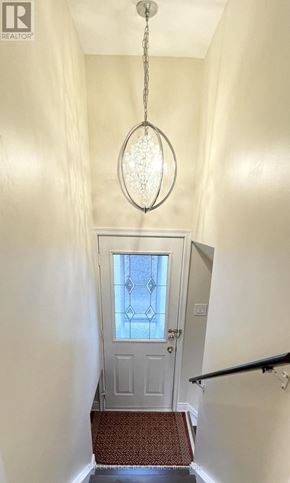 Toronto (Willowridge-Martingrove-Richview) apartment for rent - A hallway with a chandelier and a door with a glass window.