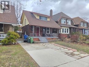 Windsor apartment for rent - A house with a brown roof and a red door is surrounded by a white fence.