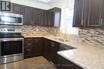 Ottawa apartment for rent - A kitchen with dark brown cabinets and a stainless steel oven.