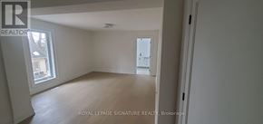 Toronto (Highland Creek) apartment for rent - A white room with a window and a door leading to another room.