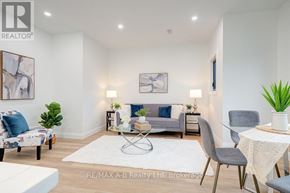 Stratford multi-family for rent - A living room with a grey couch, a white table, and a white rug.