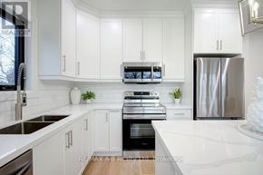 Stratford multi-family for rent - A modern kitchen with white cabinets and stainless steel appliances.