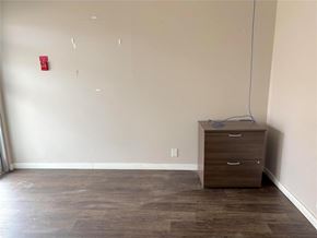 Carman apartment for rent - A room with a brown drawer cabinet and a red fire alarm on the wall.