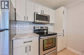 Hamilton apartment for rent - A kitchen with white cabinets and a black stove top.