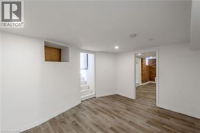 Hamilton apartment for rent - A spacious room with wooden flooring and white walls.