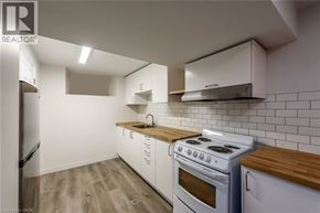 Hamilton apartment for rent - A kitchen with white cabinets and a white stove top oven.