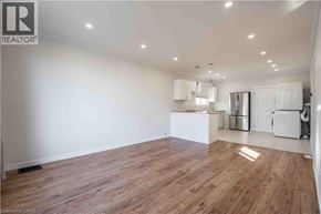 Hamilton apartment for rent - A spacious room with wooden flooring and white walls.