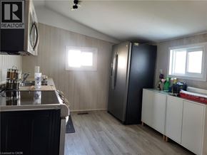 Port Colborne apartment for rent - A kitchen with a black refrigerator and white cabinets.