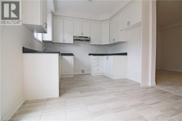 Stoney Creek apartment for rent - A kitchen with white cabinets and a black countertop.