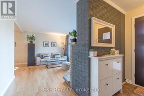 Ottawa duplex for rent - A living room with a grey brick wall and a white sofa.