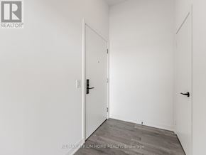 Toronto (South Parkdale) condo for rent - A white room with a door and a brokerage sign.